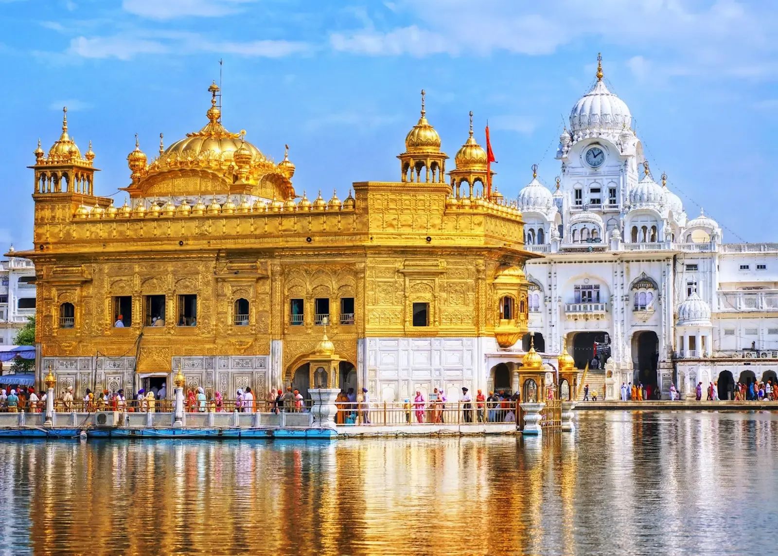 The Golden Temple across the water at close range, its gilt upper storeys bright against the white marble beside it.